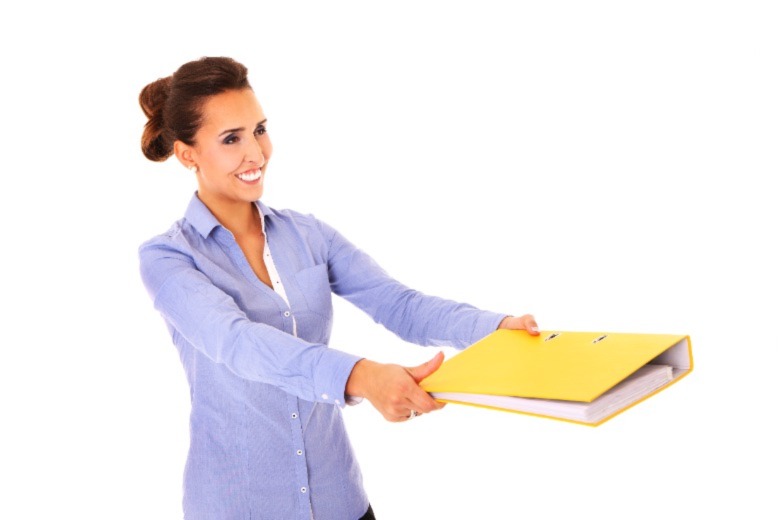 A portrait of a young pretty woman giving documents in a yellow binder over white background